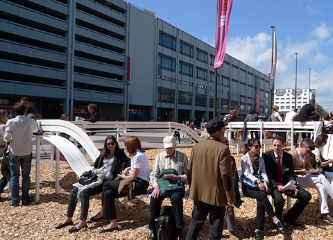 This bench seats many and orders space in the park.