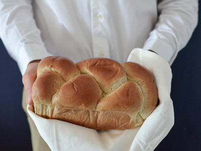 picture of person in chef's coat holding a loaf of bread; Buy Nothing