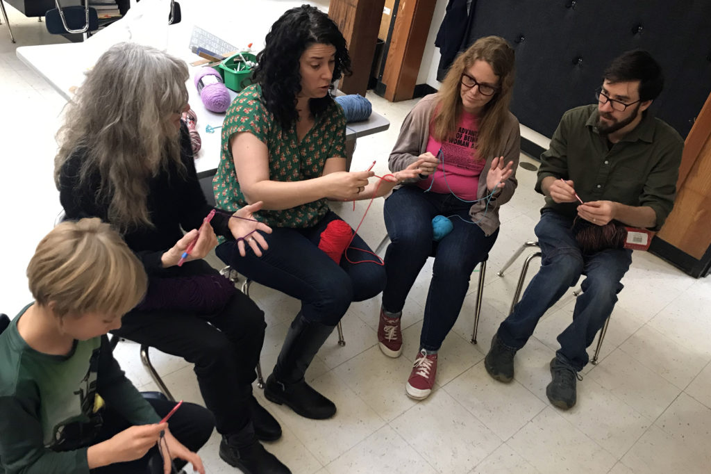 group of people learning to crochet