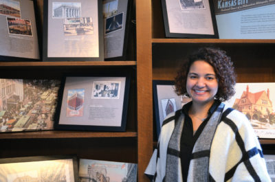 Woman smiling in front of a book stand
