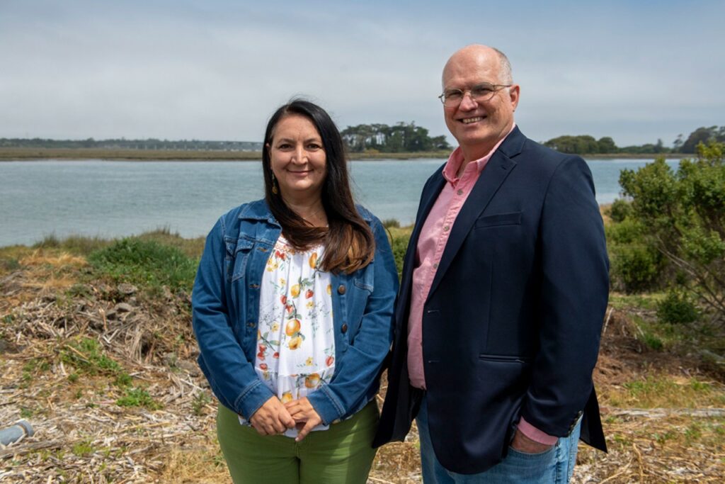 Photo of Wiyot Tribal Administrator Michelle Vassel and Cooperation Humboldt Co-founder and Executive Director David Cobb, with Tuluwat Island in the background.