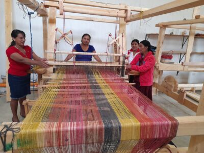 Association of Olopenses Women | Artisan women work together while weaving pita thread. Credit: AMO